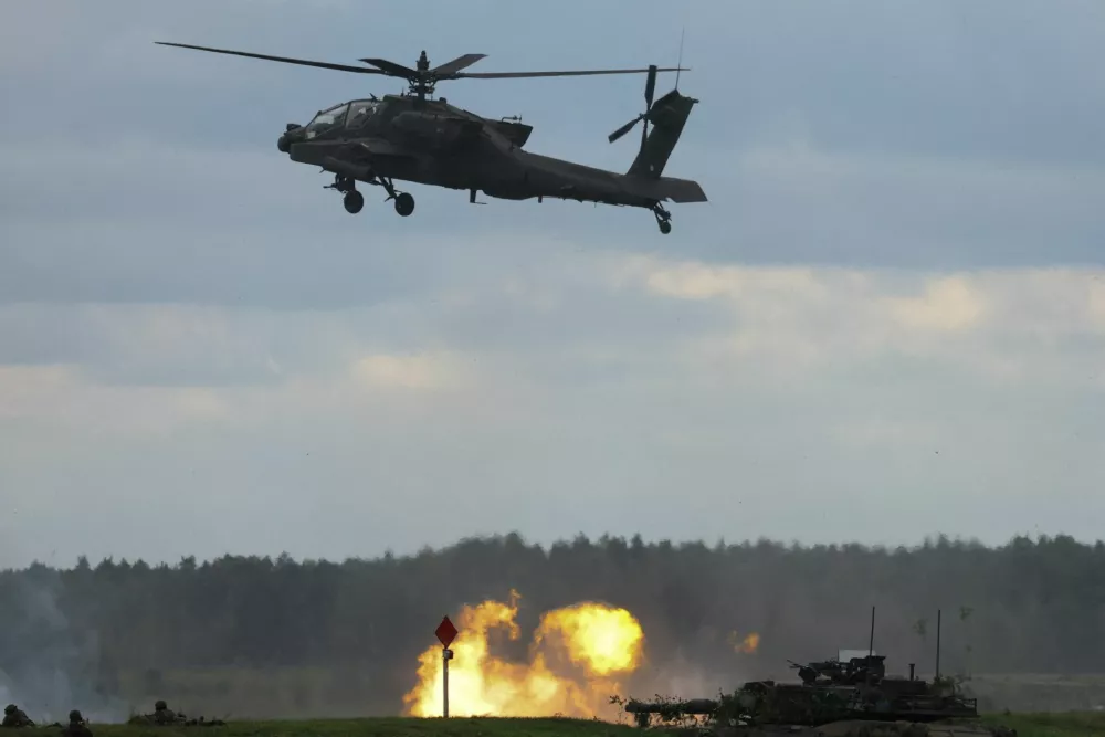 FILE PHOTO: U.S. Apache military helicopter flies over a blast as Polish forces with NATO soldiers hold 'Iron Defender' military exercises, at a military range in Wierzbiny near Orzysz, Poland, September 17, 2025. REUTERS/Kacper Pempel/File Photo