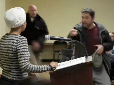 A man shouts at U.S. Representative Ilhan Omar (D-MN) after spraying an unidentified liquid in her direction, during a town hall meeting days after a man identified as Alex Pretti was fatally shot by federal immigration agents trying to detain him, in Minneapolis, Minnesota, U.S., January 27, 2026 in a still image from video. REUTERS/Maria Alejandra Cardona   TPX IMAGES OF THE DAY