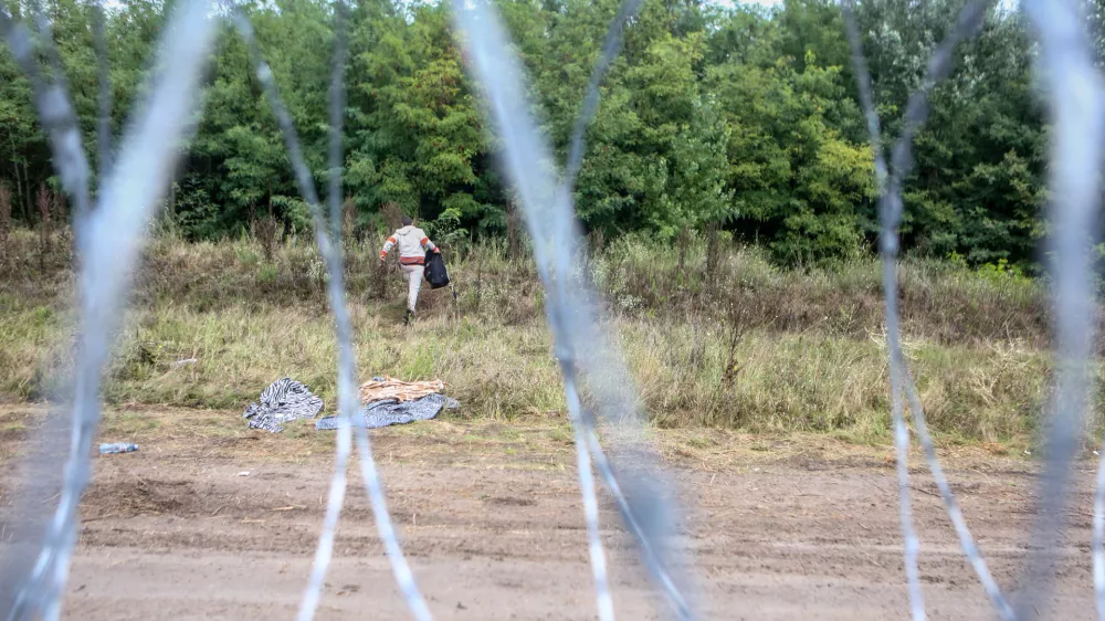 - 26.08.2015 - Madžarska - Hordos - madžarsko-srbska meja - migranti iz Sirije so prerezali ograjo in vstopili v EU - madžari so za zajezitev prebežnikov na meji s Srbijo zgradili žičnato ograjo -- Begunci 2015 - migracije po zahodni balkanski poti - migracijska pot beguncev iz Sirije, Afganistana in Iraka čez Balkan proti zahodni Evropi - evropska begunska kriza - migranti -     //FOTO: Bojan VelikonjaOPOMBA: ZA OBJAVO V PRILOGI &ndash; DNEVNIKOV OBJEKTIV - REPORTAŽA 2015 -