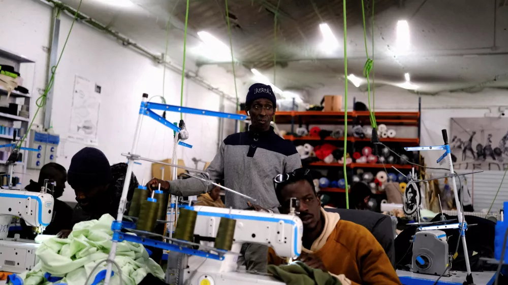 FILE PHOTO: Former street vendor and tailor immigrants sew clothes to sell the collections in a Top Manta shop in Barcelona's Raval district, Spain December 5, 2025. "Top Manta" is the name given to street vendors in Spain, where mantas (blankets) are used to display goods. REUTERS/Nacho Doce/File Photo
