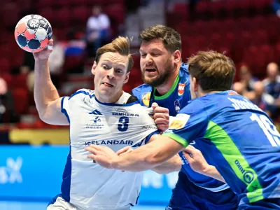 Iceland's Janus Daoi Smarason is challenged by Slovenia's Matic Suholeznik and Stas Jovicic, right, during the men's handball match between Slovenia and Iceland in Malmo, Sweden, Wednesday Jan. 28, 2026. (Johan Nilsson /TT via AP)