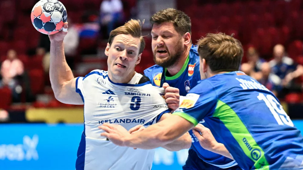 Iceland's Janus Daoi Smarason is challenged by Slovenia's Matic Suholeznik and Stas Jovicic, right, during the men's handball match between Slovenia and Iceland in Malmo, Sweden, Wednesday Jan. 28, 2026. (Johan Nilsson /TT via AP)