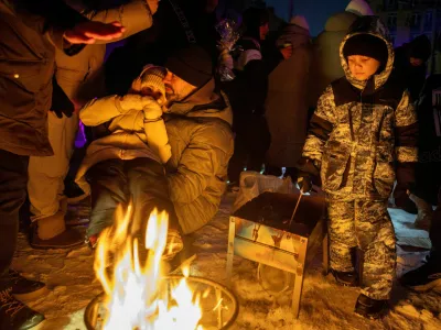 FILE PHOTO: People warm themselves at a bonfire at a party with DJ and food at a sports ground in a neighborhood left without electricity after recent Russian strikes on the capital's civilian infrastructure, amid Russia's attack on Ukraine, during sub-zero temperatures in Kyiv, Ukraine January 24, 2026. REUTERS/Thomas Peter/File Photo