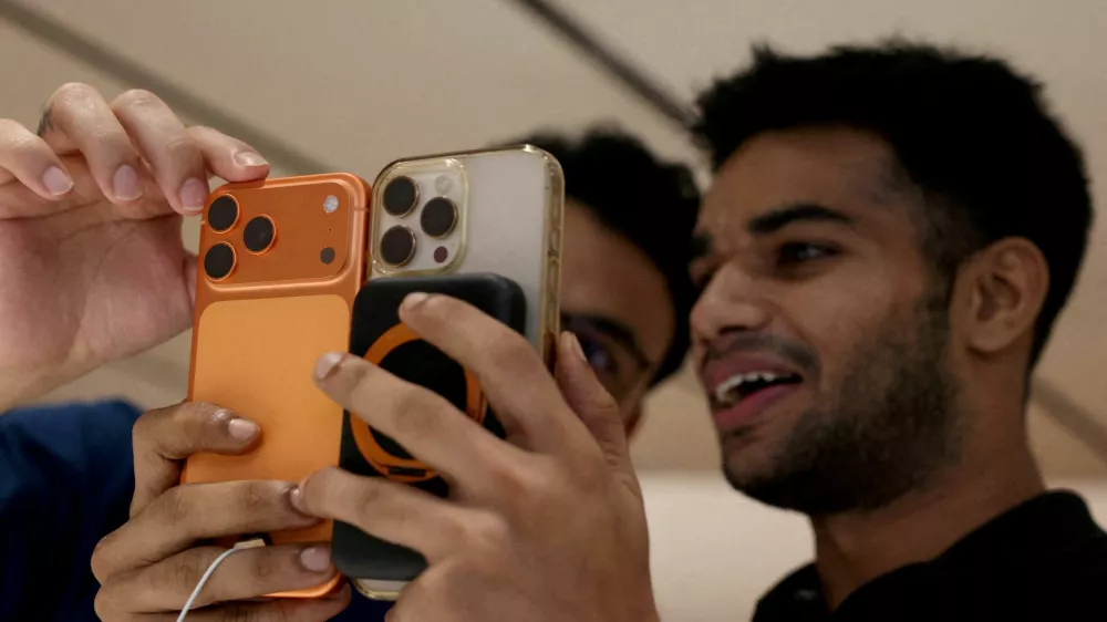 FILE PHOTO: FILE PHOTO: A customer compares his old iPhone with the newly launched iPhone 17 pro max at an Apple retail store in Delhi, India, September 19, 2025. REUTERS/Bhawika Chhabra//File Photo/File Photo