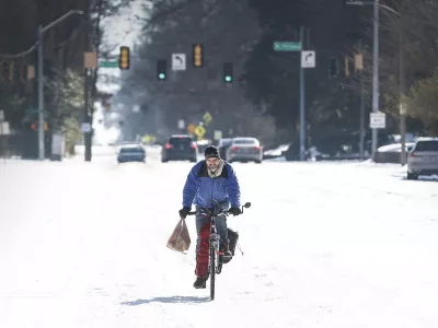 Jean Christophe rides his bike home from Kroger on snow and ice in Memphis, Tenn., Wednesday, Jan. 28, 2026. (Mark Weber/Daily Memphian via AP)