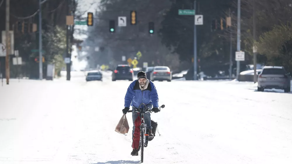 Jean Christophe rides his bike home from Kroger on snow and ice in Memphis, Tenn., Wednesday, Jan. 28, 2026. (Mark Weber/Daily Memphian via AP)