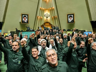 In this handout photo released by the Islamic Consultative Assembly News Agency (ICANA) Iranian lawmakers chant slogans as they wear the Revolutionary Guard's uniform in a session of parliament, in Tehran, Iran, Sunday, Feb. 1, 2026. (Hamed Malekpour/ICANA via AP)