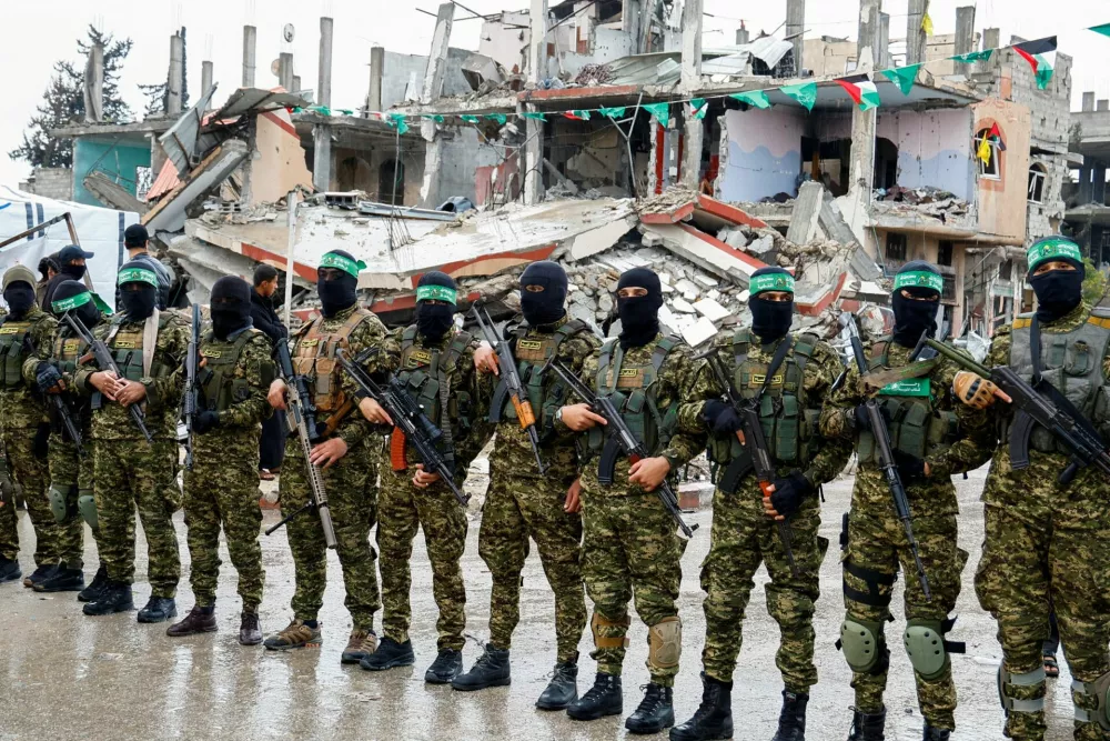 FILE PHOTO: Palestinian Hamas militants stand guard on the day of the handover of hostages held in Gaza since the deadly October 7 2023 attack, as part of a ceasefire and a hostages-prisoners swap deal between Hamas and Israel, in Rafah in the southern Gaza Strip, February 22, 2025. REUTERS/Hatem Khaled/File Photo