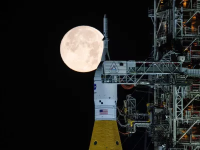 A full moon is seen shining over NASA's SLS (Space Launch System) and Orion spacecraft, atop the mobile launcher in the early hours of Sunday, Feb. 1, 2026, at NASA's Kennedy Space Center in Florida. (Sam Lott/NASA via AP)