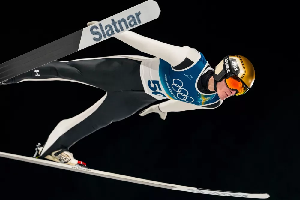 Domen Prevc, of Slovenia, soars through the air during his first round jump of the ski jumping men's normal hill individual at the 2026 Winter Olympics, in Predazzo, Italy, Monday, Feb. 9, 2026. (AP Photo/Matthias Schrader) / Foto: Matthias Schrader