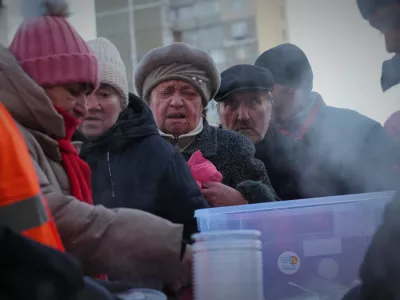 People line up to get a free hot food during a blackout caused by Russia's regular air attacks on the country's energy system in Kyiv, Ukraine, Monday, Feb. 2, 2026. (AP Photo/Sergei Grits)
