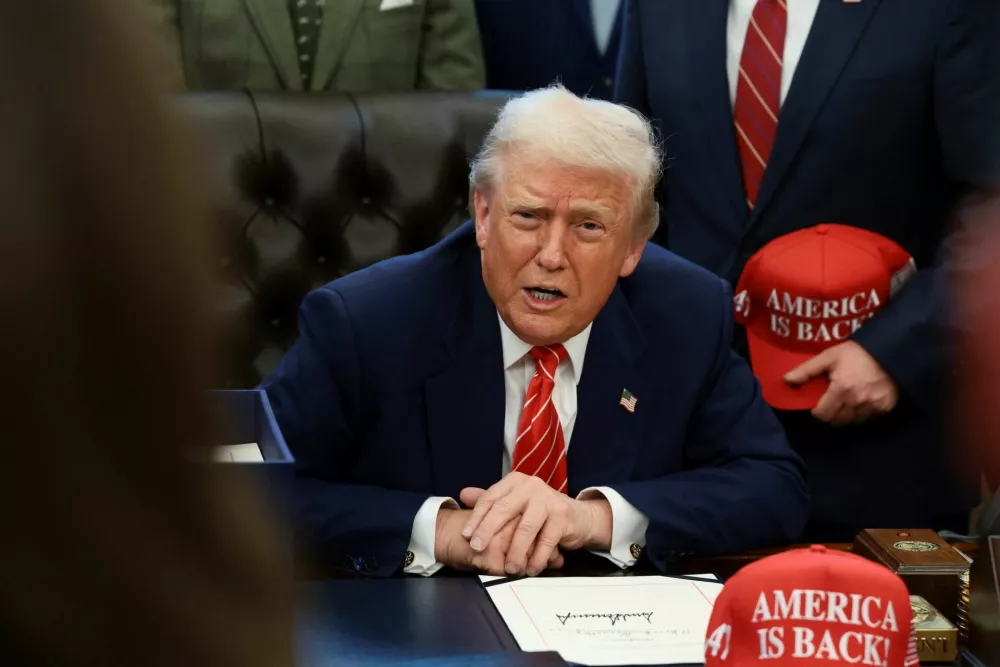 U.S. President Donald Trump sits behind a bill he signed to end the partial government shutdown, at the White House in Washington, D.C., U.S., February 3, 2026. REUTERS/Evelyn Hockstein