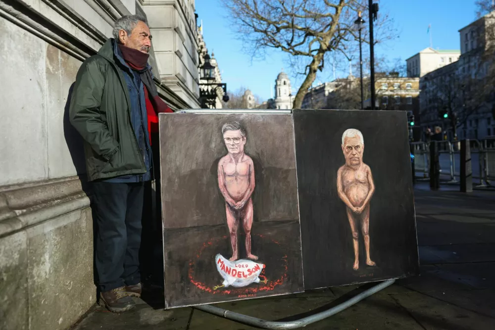 Artist Kaya Mar stands next to his satirical paintings depicting nude figures of British Prime Minister Keir Starmer and Andrew Mountbatten‑Windsor, the younger brother of Britain's King Charles, formerly Prince Andrew, Duke of York, as pressure builds on him to give evidence following the release of new U.S. Justice Department records linked to the late financier and convicted sex offender Jeffrey Epstein, titled "Mandy" and "Andy," on Downing Street in London, Britain, February 4, 2026. REUTERS/Toby Melville