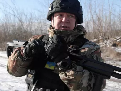 Ukrainian national police officer, holding a shotgun used as a counter-drone weapon, holds a drone fibre-optic cable, during an evacuation of residents from the Tavriiske and Yurkivka villages in Ukraine's Zaporizhzhia region, amid Russia's attack on Ukraine, in this screengrab from a video, February 3, 2026. Reuters TV via REUTERS THIS IMAGE HAS BEEN SUPPLIED BY A THIRD PARTY