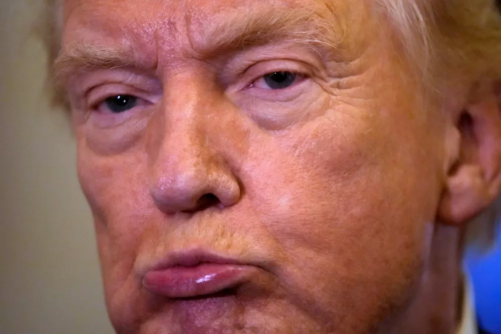 President Donald Trump listens to a reporter's question as he flies aboard Air Force One from Joint Base Andrews, Md., to West Palm Beach, Fla., Friday, Feb. 6, 2026 (AP Photo/Mark Schiefelbein)