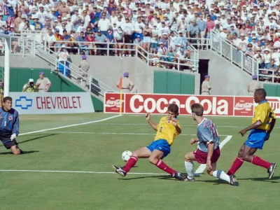 Colombian defender Andres Escobar (C) comes up short as he tries to block the shot of US forward Eric Wynalda during their World Cup match at the Rose Bowl stadium in Pasadena on June 22, 1994. The 15th FIFA World Cup took place in 1994. The United States hosted the event, which was held at nine locations nationwide from June 17 to July 17, 1994. Despite soccer's relative lack of popularity in the host country, the United States was selected, and the competition was the most profitable in World Cup history.,Image: 1046072649, License: Rights-managed, Restrictions:, Model Release: no