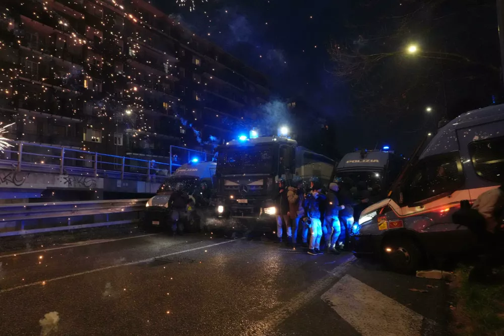Police officers block the street in from of demonstrators marching against the Milan-Cortina 2026 Olympics, in Milan, Italy, Saturday Feb. 7, 2026. (Claudio Furlan/LaPresse via AP)