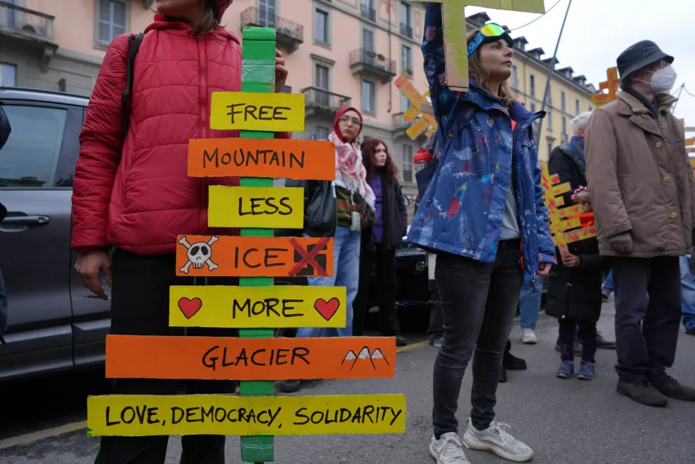 A demonstrator holding a cardboard cutouts representing trees cut down for a new bobsled run takes part in a march against the environmental impact of the Milan Cortina Winter Olympics and the presence of U.S. Immigration and Customs Enforcement agents, in Milan, Saturday Feb. 7, 2026. (Claudio Furlan/LaPresse via AP)