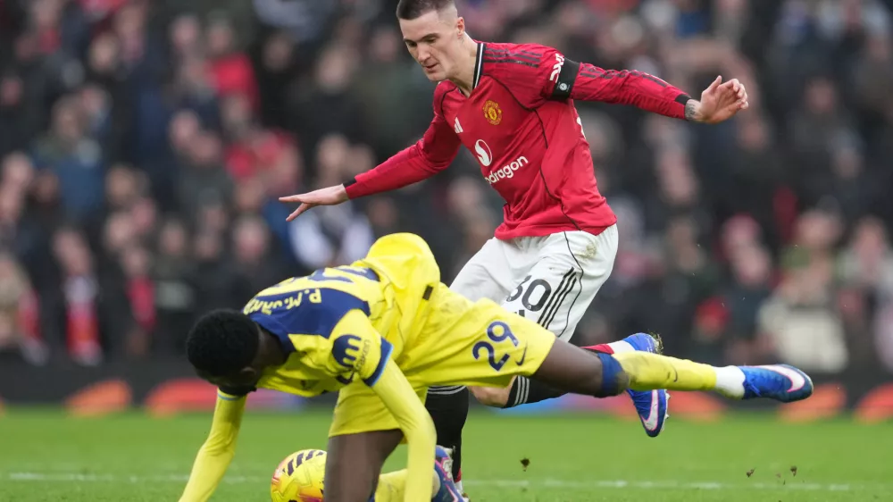 Tottenham's Pape Matar Sarr, left, and Manchester United's Benjamin Sesko fight for the ball during the English Premier League soccer match between Manchester United and Tottenham in Manchester, England, Saturday, Feb. 7, 2026. (AP Photo/Jon Super)