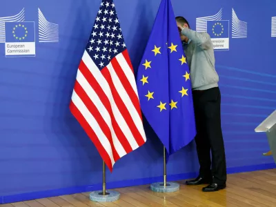 FILE PHOTO: A worker adjusts European Union and U.S. flags at the EU Commission headquarters in Brussels, November 11, 2013./File Photo