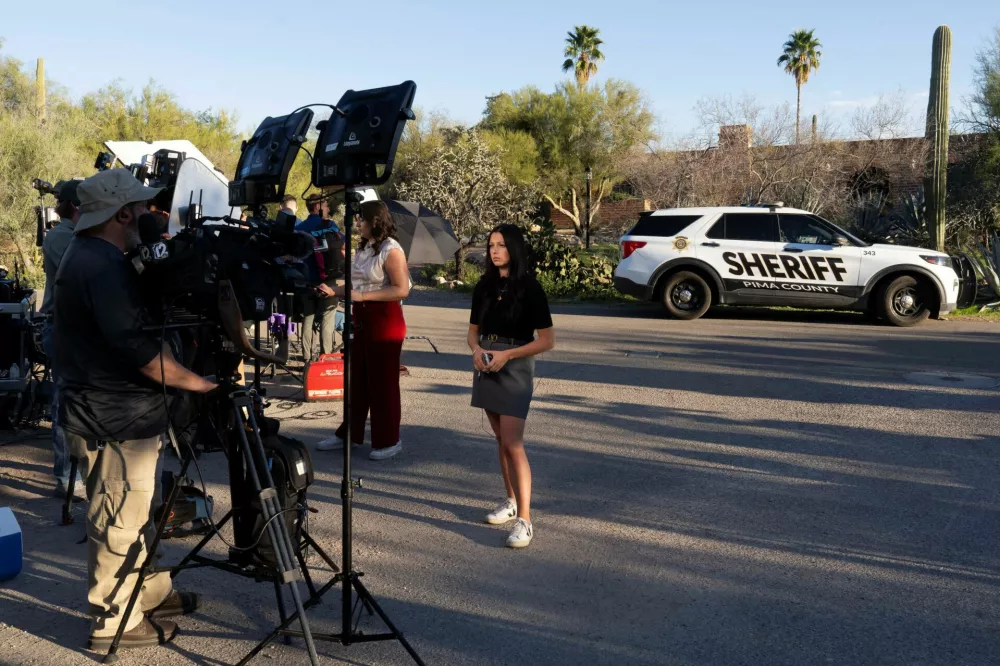 Broadcast journalists report live outside the home of Nancy Guthrie, the 84-year-old mother of U.S. journalist and television host Savannah Guthrie, who went missing from her home in Tucson, U.S. February 9, 2026. REUTERS/Rebecca Noble