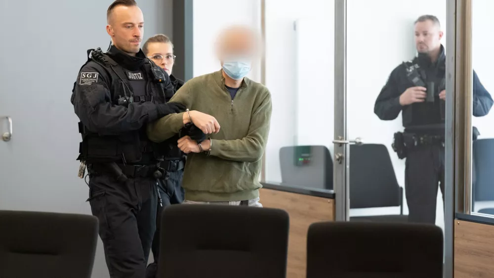 30 September 2025, Saxony, Dresden: The main defendant Jian G. (C) is escorted into the courtroom at the Dresden Higher Regional Court (OLG) prior to the announcement of the verdict in a high-profile espionage case. The proceedings concern a former employee of Alternative for Germany (AfD) parliamentarian Maximilian Krah and his alleged accomplice, accused of passing sensitive information to foreign actors. Photo: Sebastian Kahnert/dpa-pool/dpa - ACHTUNG: Der Angeklagte/ Verurteilte und andere prozessbeteiligte Person(en) wurde(n) aus rechtlichen Gr&uuml;nden gepixelt
