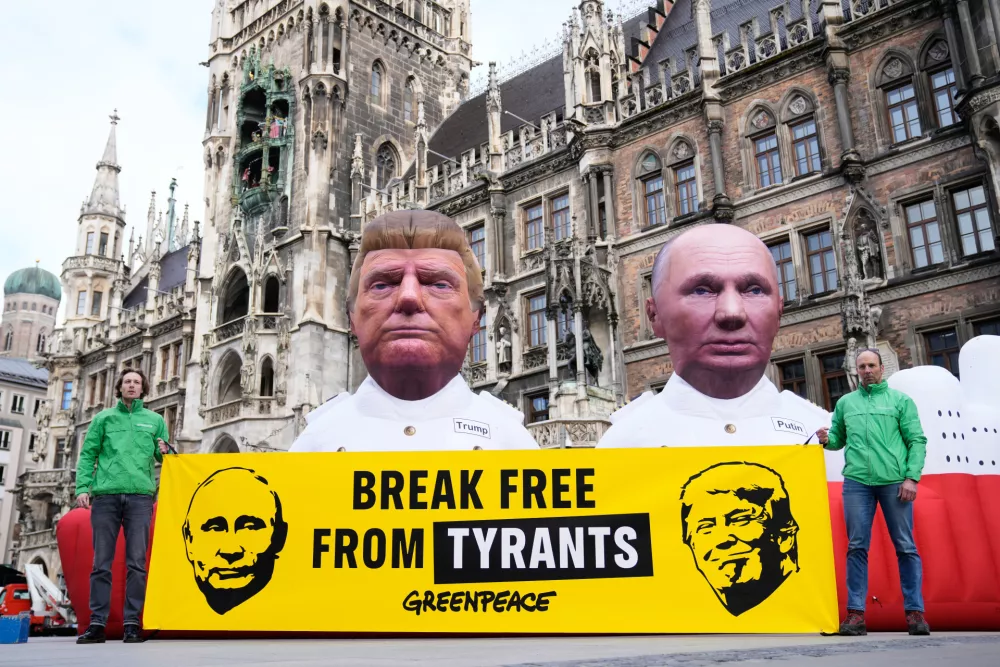 Figures depicting US President Donald Trump and Russian President Vladimir Putin, right, are displayed at Marienplatz square, as part of a protest against fossil energy by the environment organisation Greenpeace during the Munich Security Conference in Munich, Germany, Friday, Feb. 13, 2026. (AP Photo/Ebrahim Noroozi)