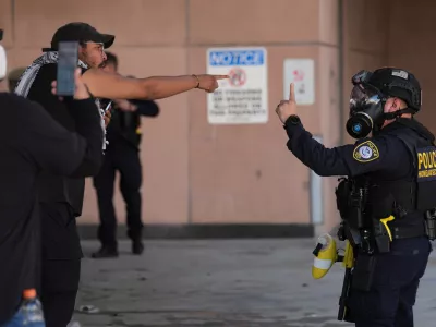 Protestors protests with U.S. Immigration and Customs Enforcement (ICE) agents outside the Los Angeles Metropolitan Detention Center (MDC Los Angeles) as part of the nationwide Spring Surge to Melt ICE! on Friday, Feb. 13, 2026. (AP Photo/Damian Dovarganes)