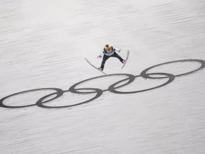 Domen Prevc, of Slovenia, soars through the air during his first round jump of the ski jumping men's large hill individual at the 2026 Winter Olympics, in Predazzo, Italy, Saturday, Feb. 14, 2026. (AP Photo/Matthias Schrader) / Foto: Matthias Schrader