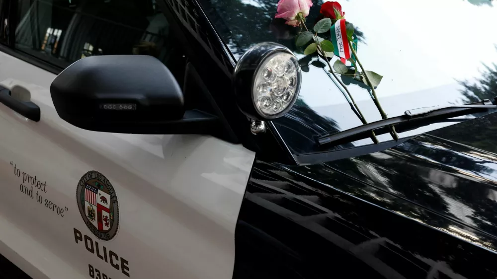 Flowers are placed on a police vehicle as people take part in a rally in support of Iranian protesters during a global day of action in Los Angeles, California, U.S., February 14, 2026.  REUTERS/Caroline Brehman