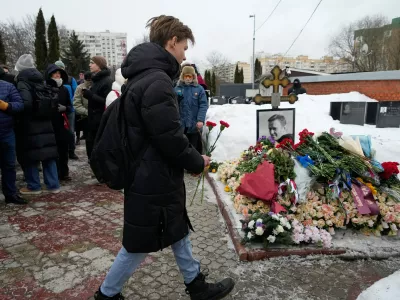 A man lays flowers at Russian opposition leader Alexei Navalny's grave, two years after his death, at the Borisovskoye Cemetery in Moscow, on Monday, Feb. 16, 2026. (AP Photo/Alexander Zemlianichenko)
