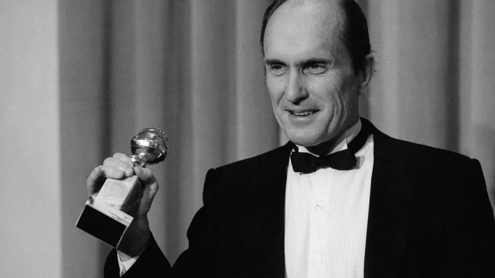 FILE - Actor Robert Duvall holds the Golden Globe award he won for best actor in a dramatic motion picture for his role in "Tender Mercies" in Beverly Hills, Calif., on Jan. 29,198 4. (AP Photo/Lennox Mclendon, File)