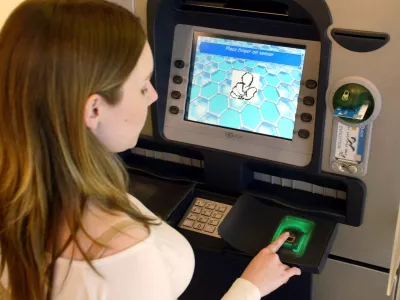 The display screen of an ATM machine at NCR in Dundee asks customer Aileen Hird to place her fingertip on the scanner, as verification of identity. Dundee, Scotland, Friday, May. 20, 2005. Scanning fingerprints or irises to verify a customer's identity has yet to penetrate the U.S. banking market, due to concerns about expense and privacy. (AP Photo/Martin Cleaver)