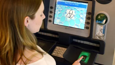 The display screen of an ATM machine at NCR in Dundee asks customer Aileen Hird to place her fingertip on the scanner, as verification of identity. Dundee, Scotland, Friday, May. 20, 2005. Scanning fingerprints or irises to verify a customer's identity has yet to penetrate the U.S. banking market, due to concerns about expense and privacy. (AP Photo/Martin Cleaver)