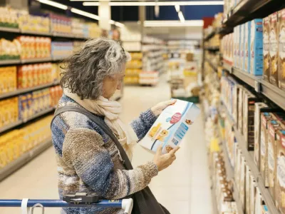 Senior adult woman reading product information on a cereal box while shopping at the grocery store / Foto: Jordi Salas