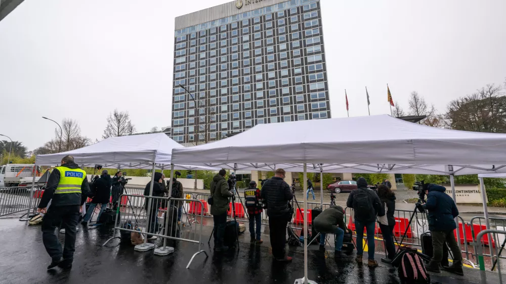 Journalists gather outside the entrance of the Intercontinental Hotel where U.S., Ukraine and Russia are meeting to discuss peace plan, in Geneva, Switzerland, Wednesday, Feb. 18, 2026. (Martial Trezzini/Keystone via AP)