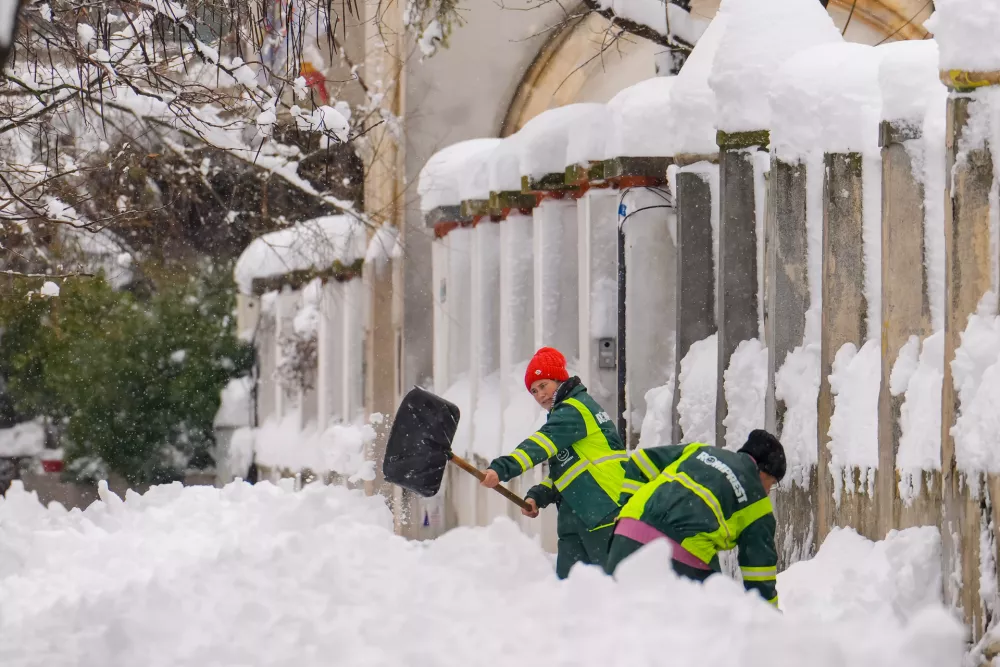 Municipal workers shovel snow after a blizzard in Bucharest, Romania, Wednesday, Feb. 18, 2026. (AP Photo/Vadim Ghirda)