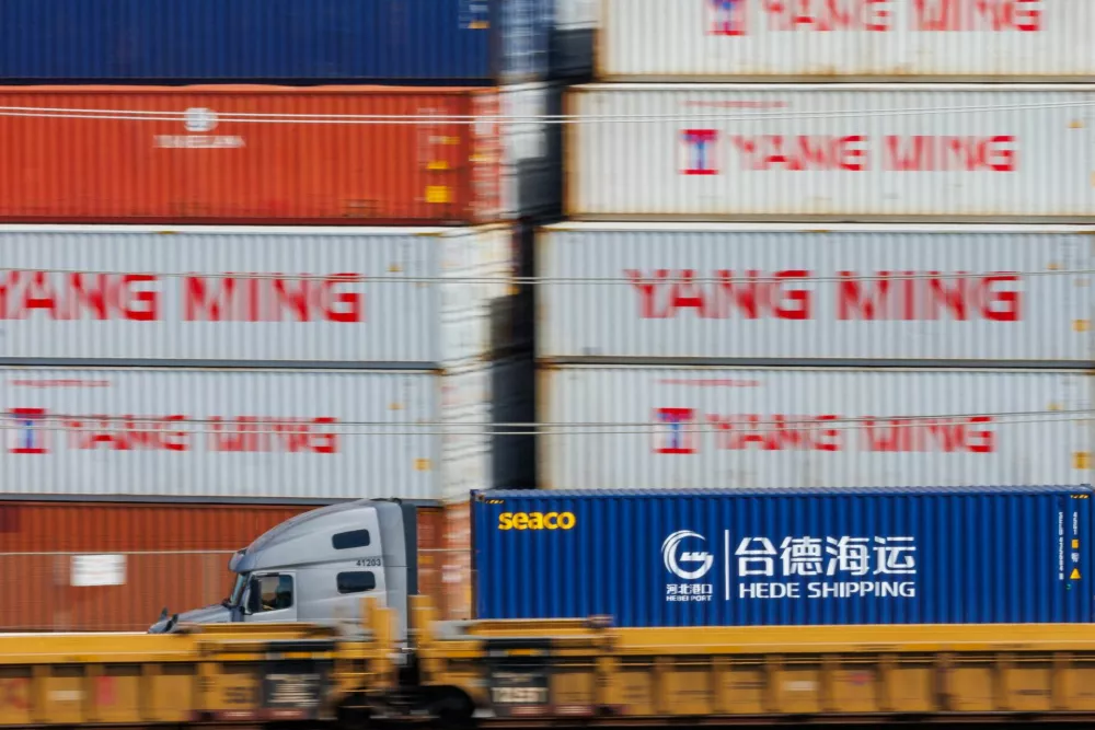 A trucker drives his cargo past shipping containers at the West Basin Container Terminal at the Port of Los Angeles in Los Angeles, California, U.S., February 24, 2026. REUTERS/Mike Blake/ / Foto: Mike Blake