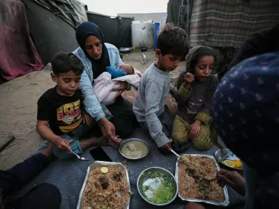Displaced members of the Al-Zamli family break their fast on the first day of Ramadan inside their tent in Khan Younis, Gaza Strip, Wednesday, Feb. 18, 2026. (AP Photo/Jehad Alshrafi)