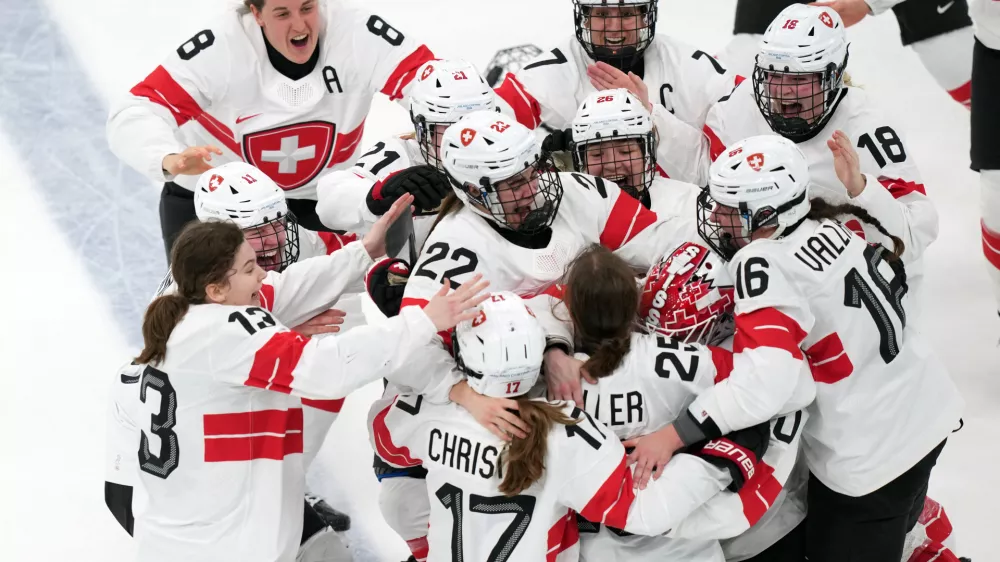 Team Switzerland players celebrate after Alina Muller (25) scored the winning goal in overtime to beat Sweden in the women's ice hockey bronze medal game at the 2026 Winter Olympics, in Milan, Italy, Thursday, Feb. 19, 2026. (AP Photo/Carolyn Kaster)