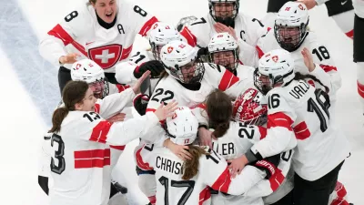 Team Switzerland players celebrate after Alina Muller (25) scored the winning goal in overtime to beat Sweden in the women's ice hockey bronze medal game at the 2026 Winter Olympics, in Milan, Italy, Thursday, Feb. 19, 2026. (AP Photo/Carolyn Kaster)