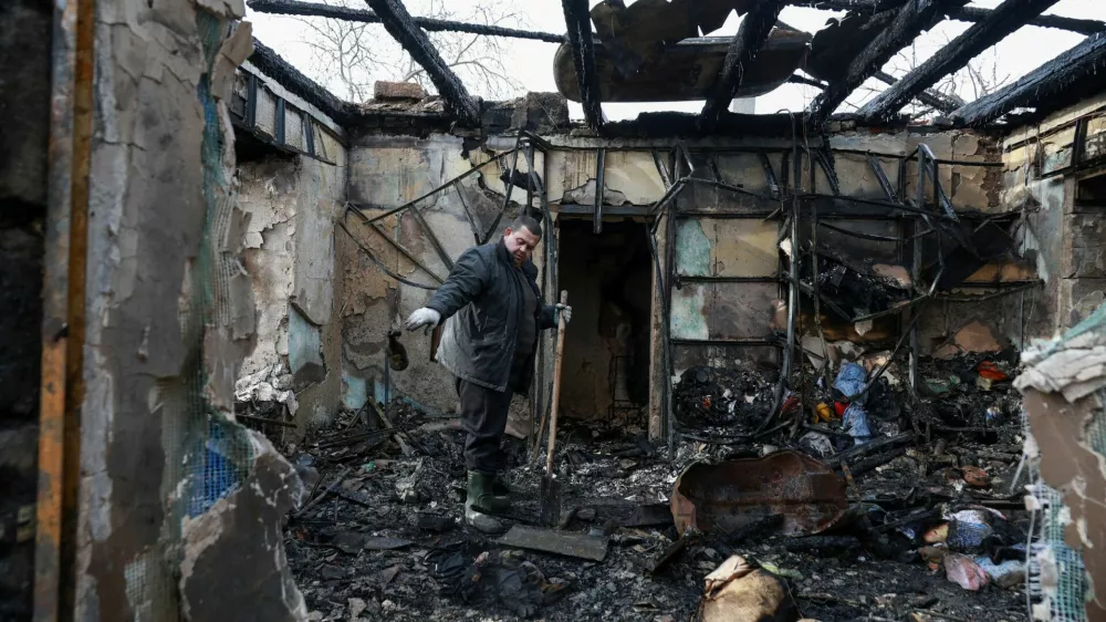 A resident removes debris from his house, which was hit by a Russian drone strike, amid Russia's attack on Ukraine, in Odesa, Ukraine February 21, 2026. REUTERS/Nina Liashonok   TPX IMAGES OF THE DAY