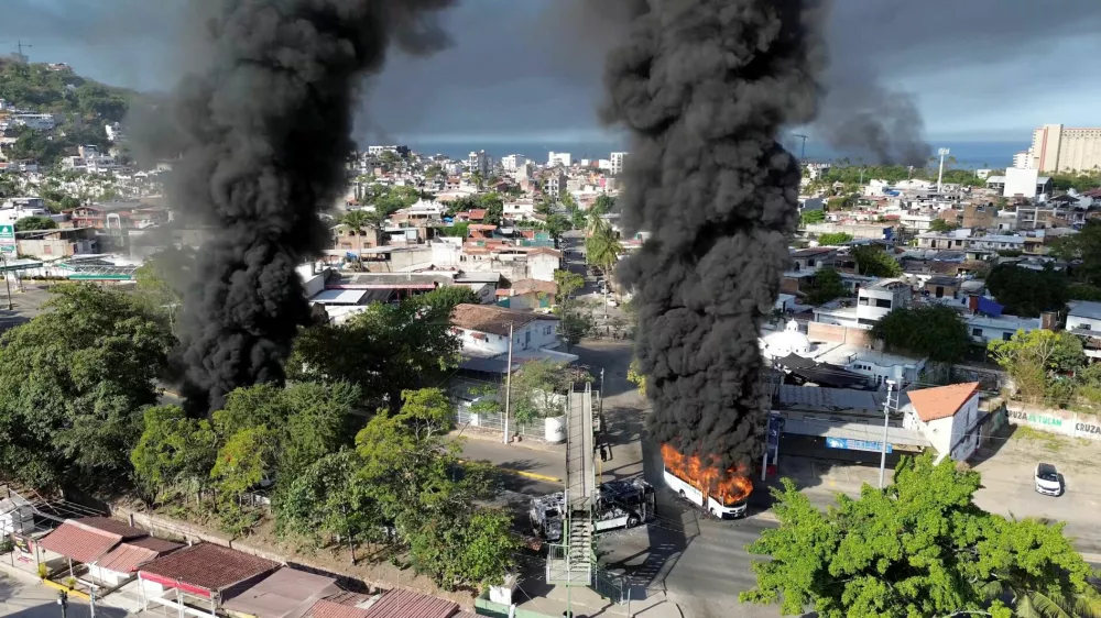 Smoke billows from burning vehicles amid a wave of violence, with torched vehicles and gunmen blocking highways in more than half a dozen states, following a military operation in which a government source said Mexican drug lord Nemesio Oseguera, known as "El Mencho," was killed, in Puerto Vallarta, Jalisco, Mexico, February 22, 2026, in this screen grab obtained from a social media video. @morelifediares via Instagram/Youtube/via REUTERS THIS IMAGE HAS BEEN SUPPLIED BY A THIRD PARTY. MANDATORY CREDIT. NO RESALES. NO ARCHIVES. TPX IMAGES OF THE DAY Verification: Reuters confirmed the location as Puerto Vallarta by the road layout, trees, buildings and businesses logos which matched file and satellite imagery. The shape of the mountains matched topography mapping. The date when the videos were filmed was verified by original file metadata.