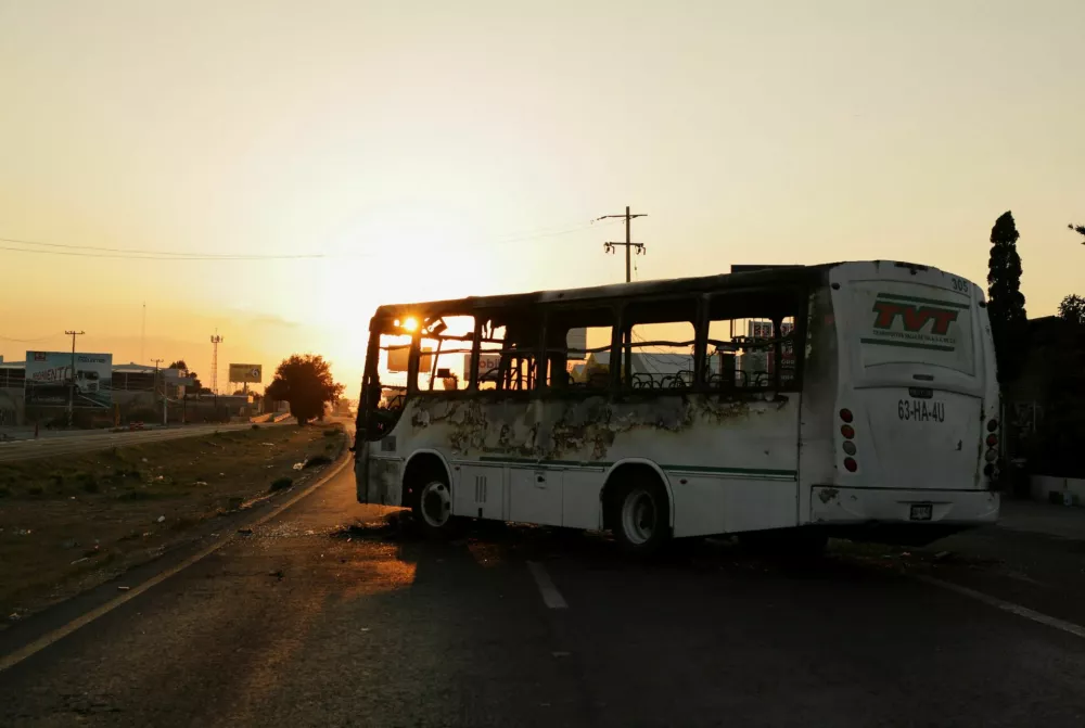 A bus consumed by flames and set up as a blockade by members of organized crime following a military operation in which Mexican officials said cartel boss Nemesio Oseguera, "El Mencho," was killed, at a tourist area, in Zapopan, Mexico, February 22, 2026. REUTERS/Gabriel Trujillo