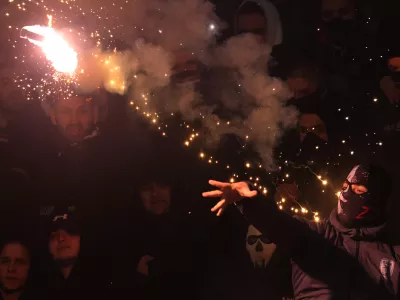 A Partizan soccer fan hits torch during a Serbian National soccer league derby match between Red Star and Partizan in Belgrade, Serbia, Sunday, Feb. 22, 2026. (AP Photo/Darko Vojinovic)