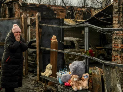 A woman reacts as she commemorates a family of two adult and three children, local residents who were killed on Friday, February 9, at their house that burned in a Russian drone strike, amid Russia's attack on Ukraine, in Kharkiv, Ukraine February 12, 2024. REUTERS/Vladyslav Musiienko