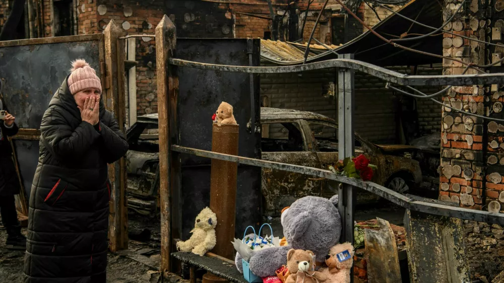 A woman reacts as she commemorates a family of two adult and three children, local residents who were killed on Friday, February 9, at their house that burned in a Russian drone strike, amid Russia's attack on Ukraine, in Kharkiv, Ukraine February 12, 2024. REUTERS/Vladyslav Musiienko