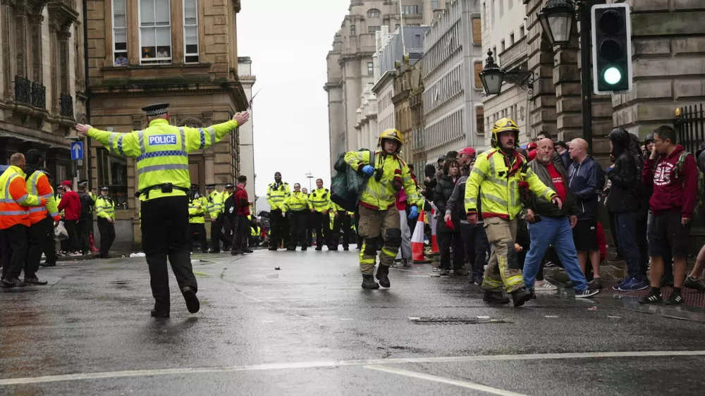 Police and emergency personnel deal with an incident on Water Street near the Liver Building in Liverpool after a car collided with pedestrians during the Premier League winners parade, in Liverpool, England, Monday May 26, 2025. (Owen Humphreys/PA via AP)