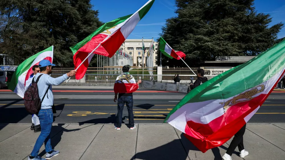 Demonstrators hold the "Lion and Sun" pre-Iranian Revolution national flags during a protest against Iran's government in front of the United Nations Office at Geneva, on the day of a new round of indirect U.S.-Iran talks over their long-running nuclear dispute, in Geneva, Switzerland, February 26, 2026. REUTERS/Pierre Albouy