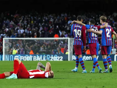 Barcelona's Frenkie de Jong, right, Barcelona's Jordi Alba, center, and Barcelona's Ferran Torres celebrate end of a Spanish La Liga soccer match between FC Barcelona and Atletico Madrid at the Camp Nou stadium in Barcelona, Spain, Sunday, Feb. 6, 2022. (AP Photo/Joan Monfort)